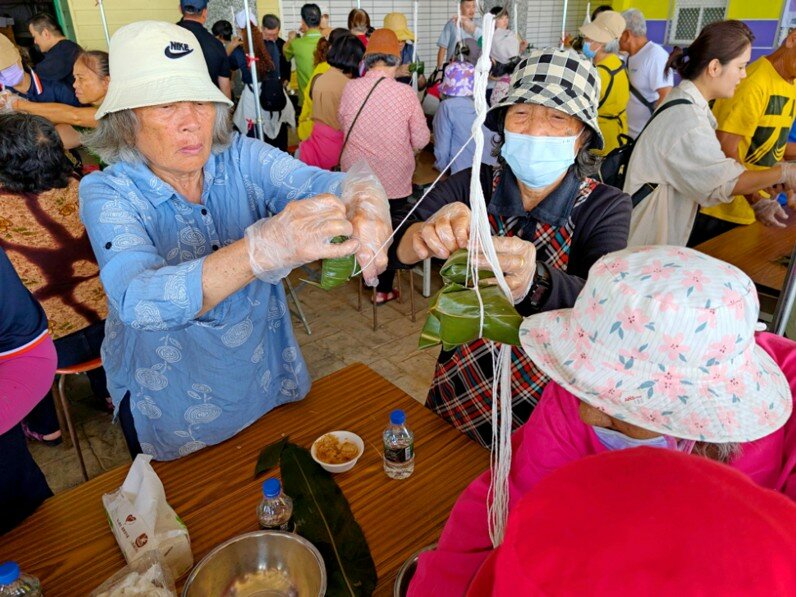 綠色照顧計畫中的「綠飲食」強調地產地銷、營養健康、文化傳承，圖為三民社區、博愛社區結合成功鎮農會家政班，選用台東成功盛產的鬼頭刀與木虌果包粽。（圖片來源／農村水保署）