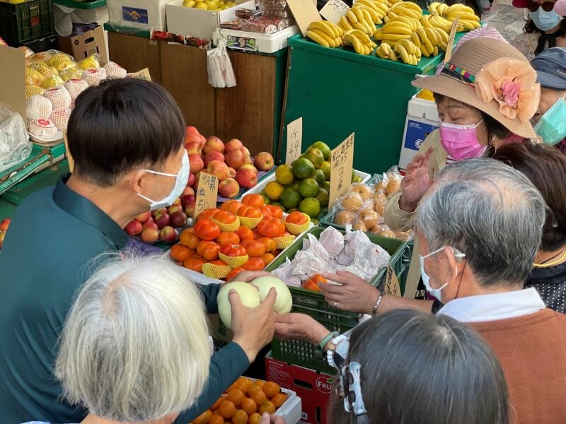 惠生大藥局人員和長輩到市場挑選食材，同時了解營養攝取議題。（圖片來源/廖昱喬）